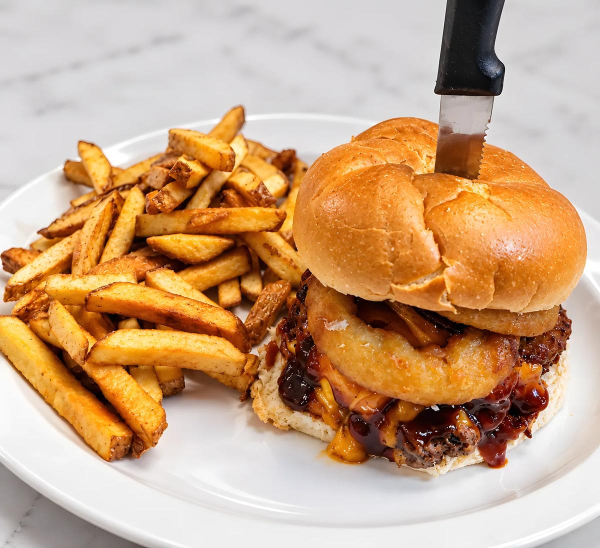 Burger with an onion ring and fries